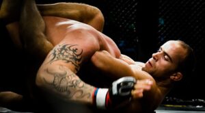Combattimento di MMA con tecnica di sottomissione al suolo in un match professionale